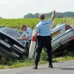 Des gendarmes près de deux voitures accidentées.