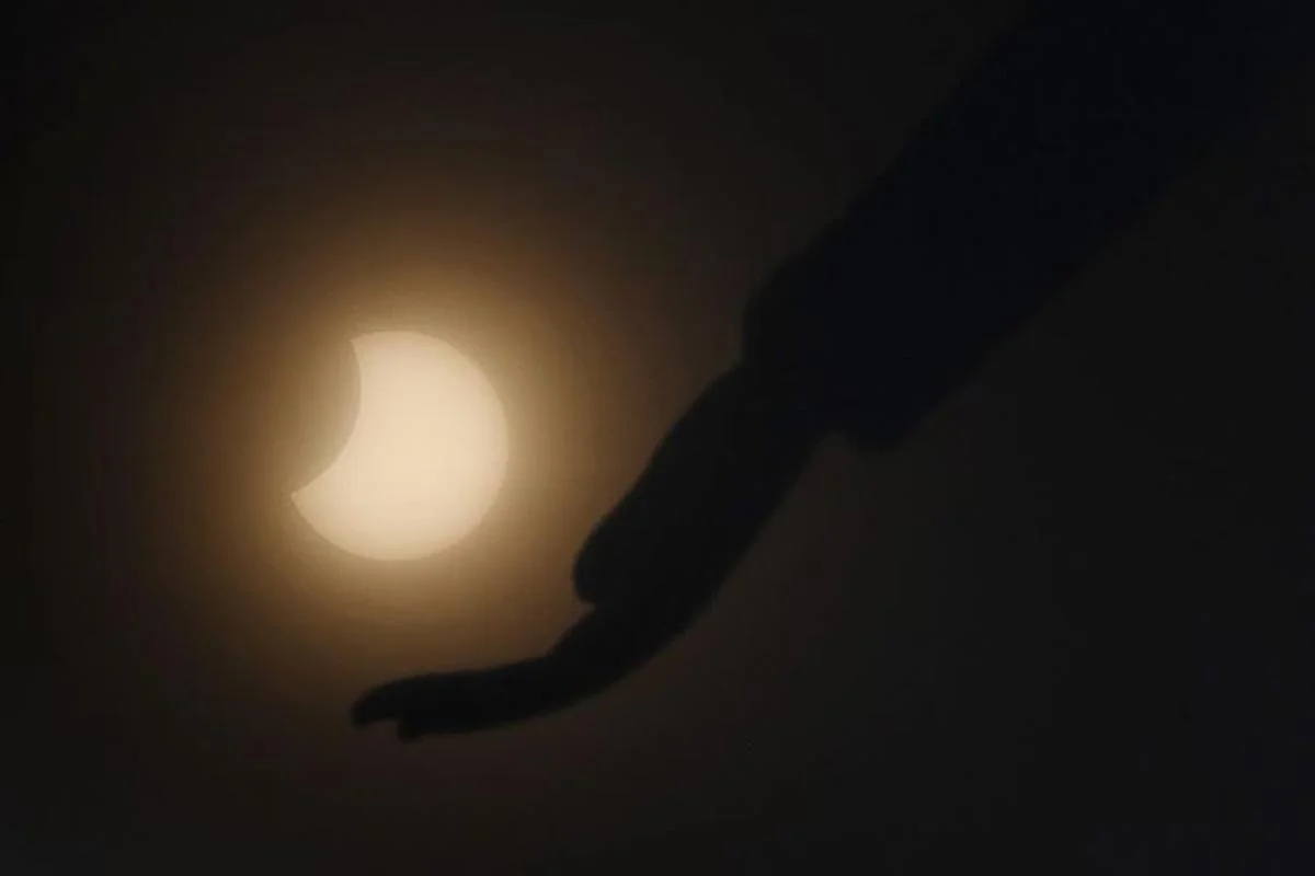 La lune se déplace devant le soleil pendant l'éclipse solaire annulaire, vue à travers les nuages depuis Chennai.