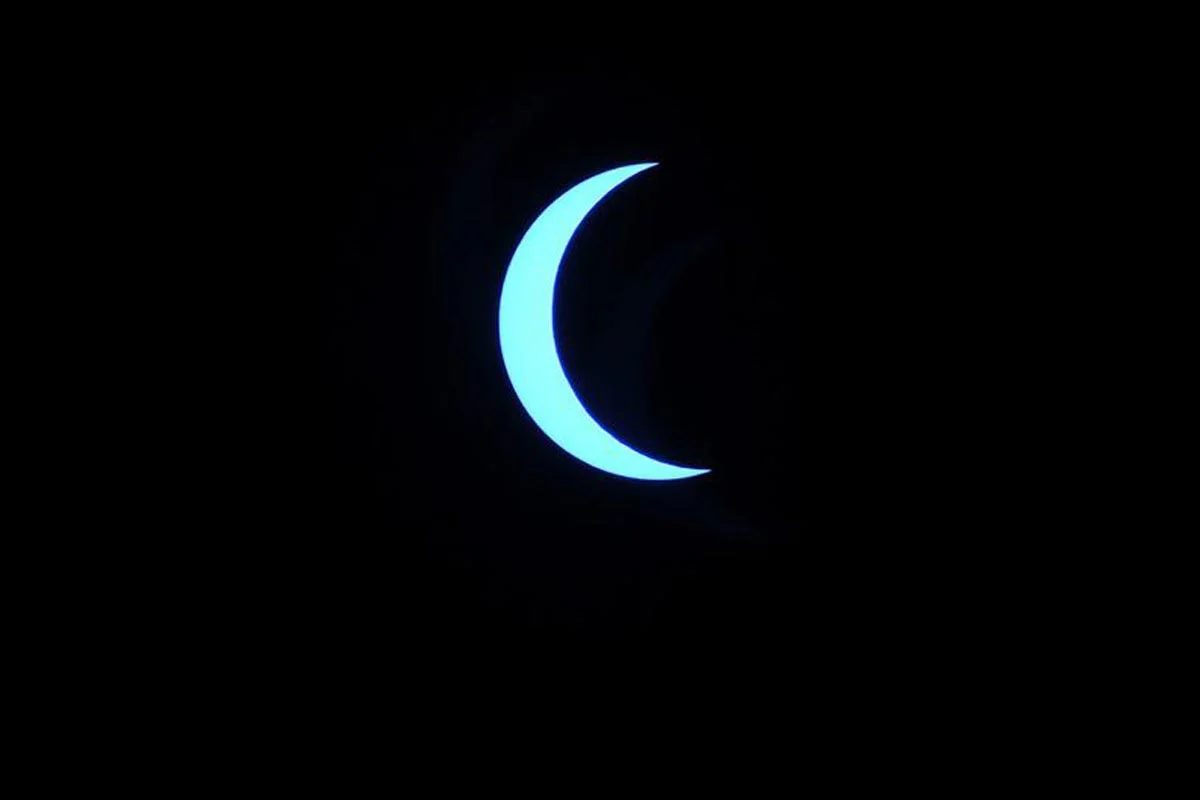 La lune se déplace devant le soleil pendant l'éclipse solaire annulaire, vue à travers les nuages depuis Katmandou.