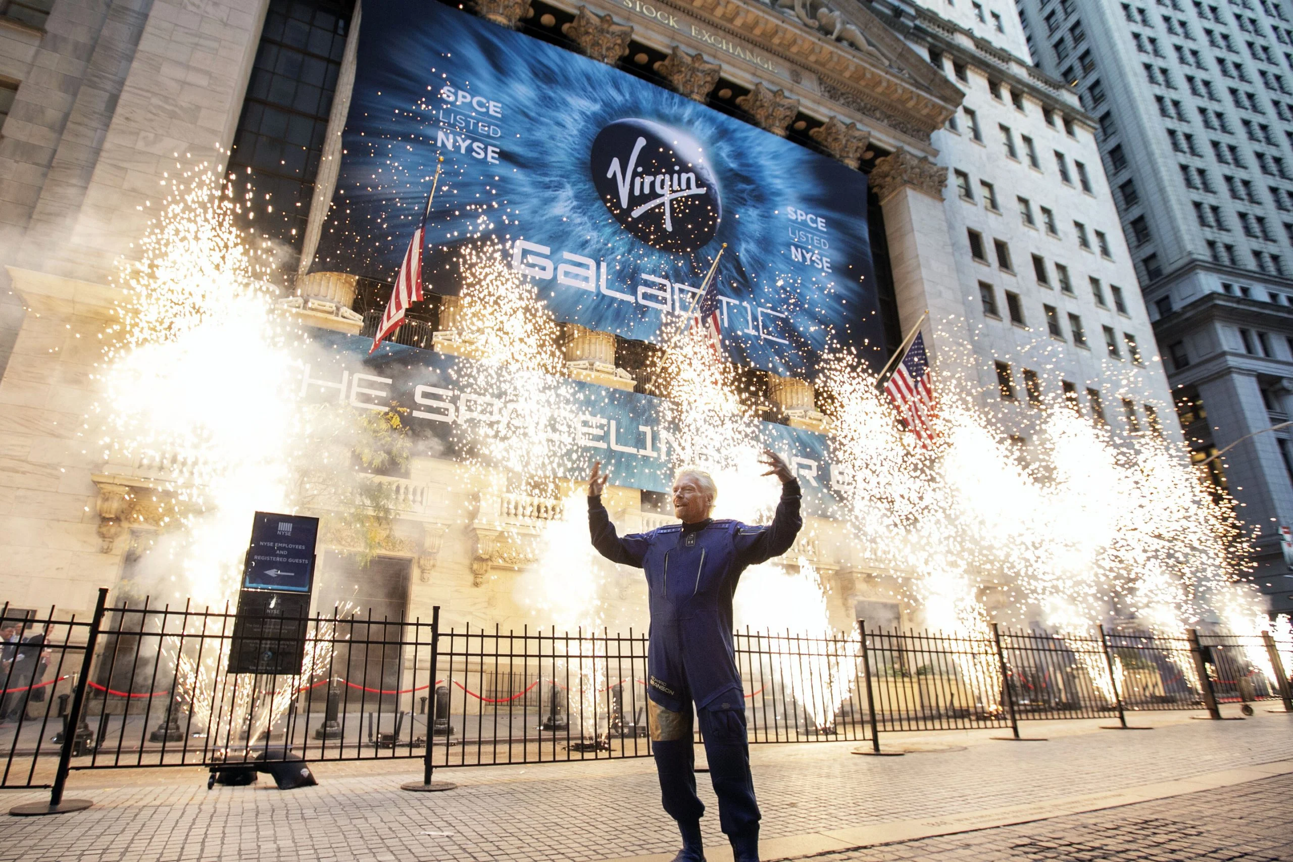 Dans ce dossier photo du lundi 28 octobre 2019, Sir Richard Branson, fondateur de Virgin Galactic, pose pour une photo à l'extérieur de la bourse de New York alors que des feux d'artifice sont tirés avant l'introduction en bourse de sa société. En 2020, l'administrateur de la NASA Jim Bridenstine a déclaré que l'espace est actuellement un marché de 400 milliards de dollars, y compris les satellites. L'ouverture des vols spatiaux aux clients payants, a-t-il dit, pourrait étendre le marché à 1 000 milliards de dollars.