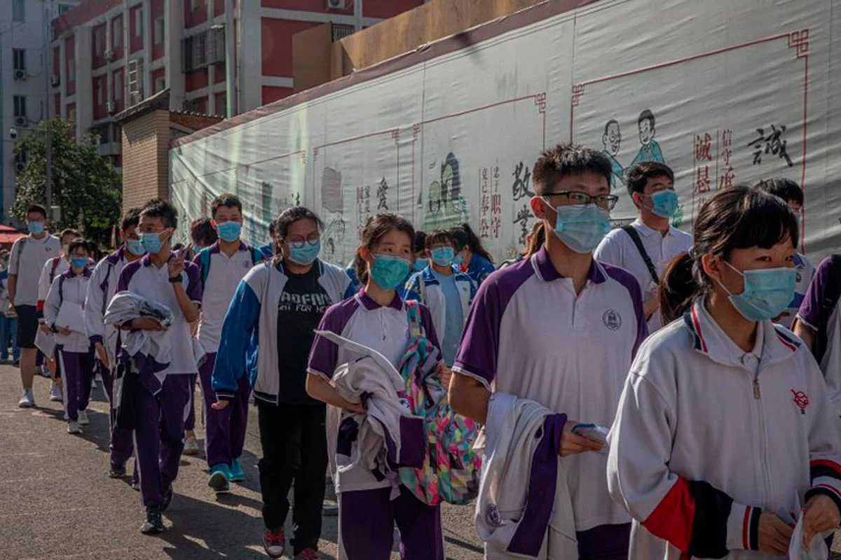 Les étudiants masqués attendent d'entrer dans une école pour assister au premier jour des examens annuels d'entrée à l'Université nationale chinoise de Pékin.