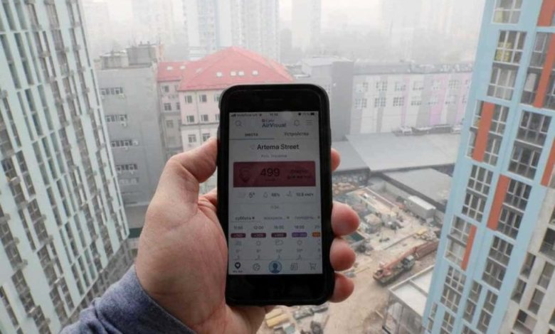 Photo d'archives d'un homme mesurant la qualité de l'air à Kiev avec une application pour smartphone.