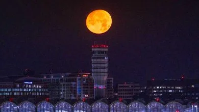 La lune presque pleine se couche sur l'aéroport national Reagan au début du 12 juillet 2022.