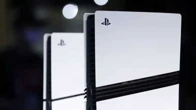 Console PlayStation 5 vue de près, avec des reflets lumineux en arrière-plan.