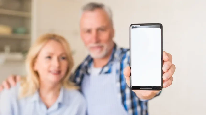 Un couple de plus de 40 ans montre un smartphone, mettant en lumière les usages du téléphone à un âge où la santé visuelle et mentale devient une priorité.