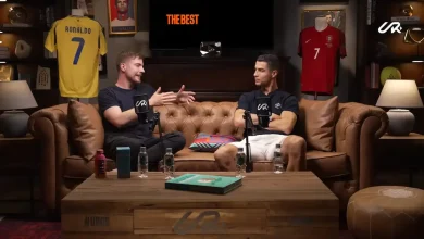 Cristiano Ronaldo et MrBeast discutant dans un cadre convivial, entourés de maillots de football et d’objets de collection, capturant leur collaboration numérique exceptionnelle.