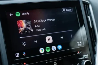 Écran d’une voiture affichant l’interface Android Auto avec Spotify en lecture, mettant en avant une navigation simplifiée et un lecteur multimédia optimisé.