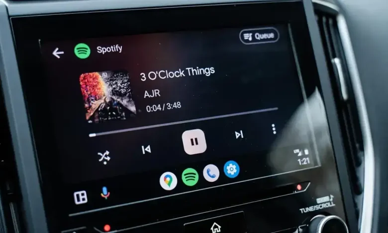 Écran d’une voiture affichant l’interface Android Auto avec Spotify en lecture, mettant en avant une navigation simplifiée et un lecteur multimédia optimisé.