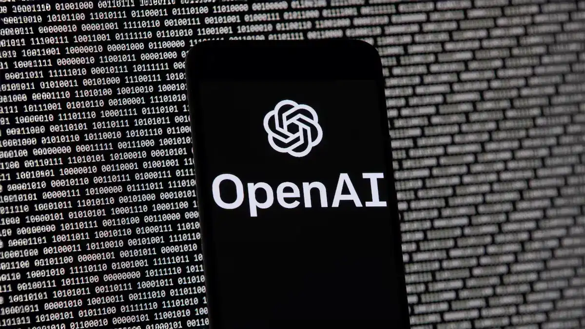 Smartphone affichant logo OpenAI, arrière-plan ChatGPT et code binaire