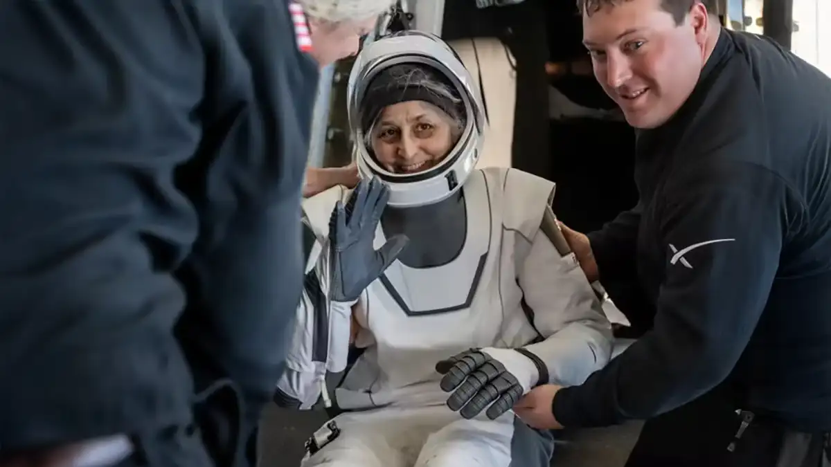 Suni Williams, souriante dans sa combinaison spatiale de SpaceX, est assistée après son retour sur Terre après neuf mois à bord de l’ISS.